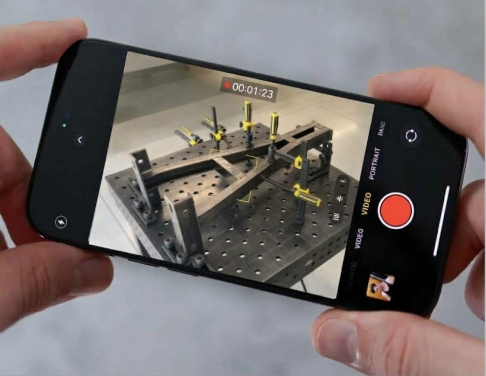 A smartphone records the part and fixtures in a welding cell